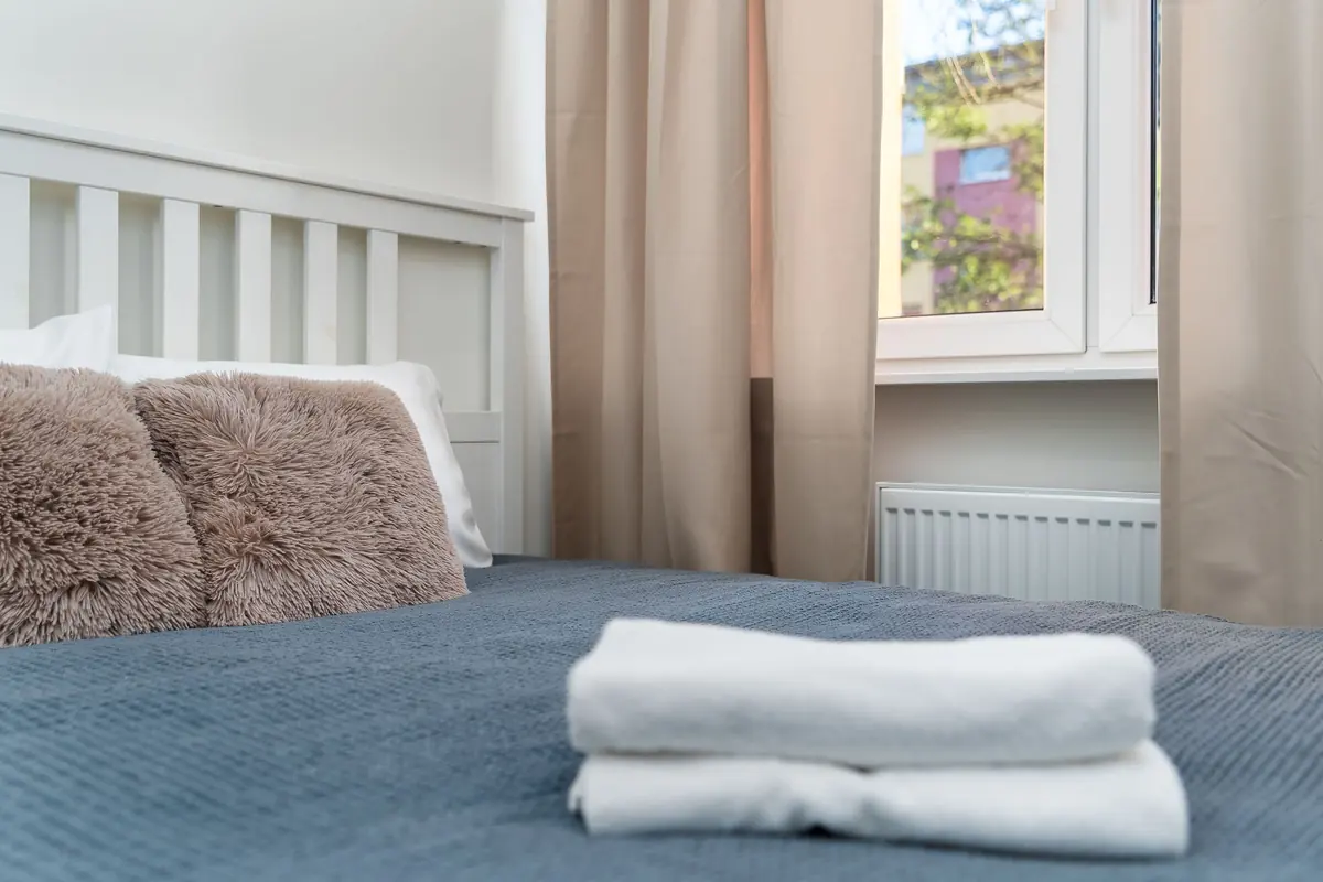 Serviettes blanches pliées sur un lit fait