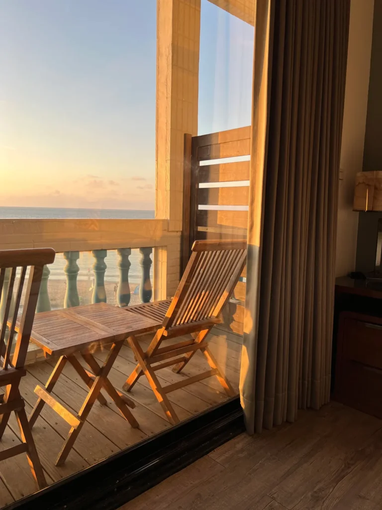 Balcon avec table et chaises en bois au coucher du soleil