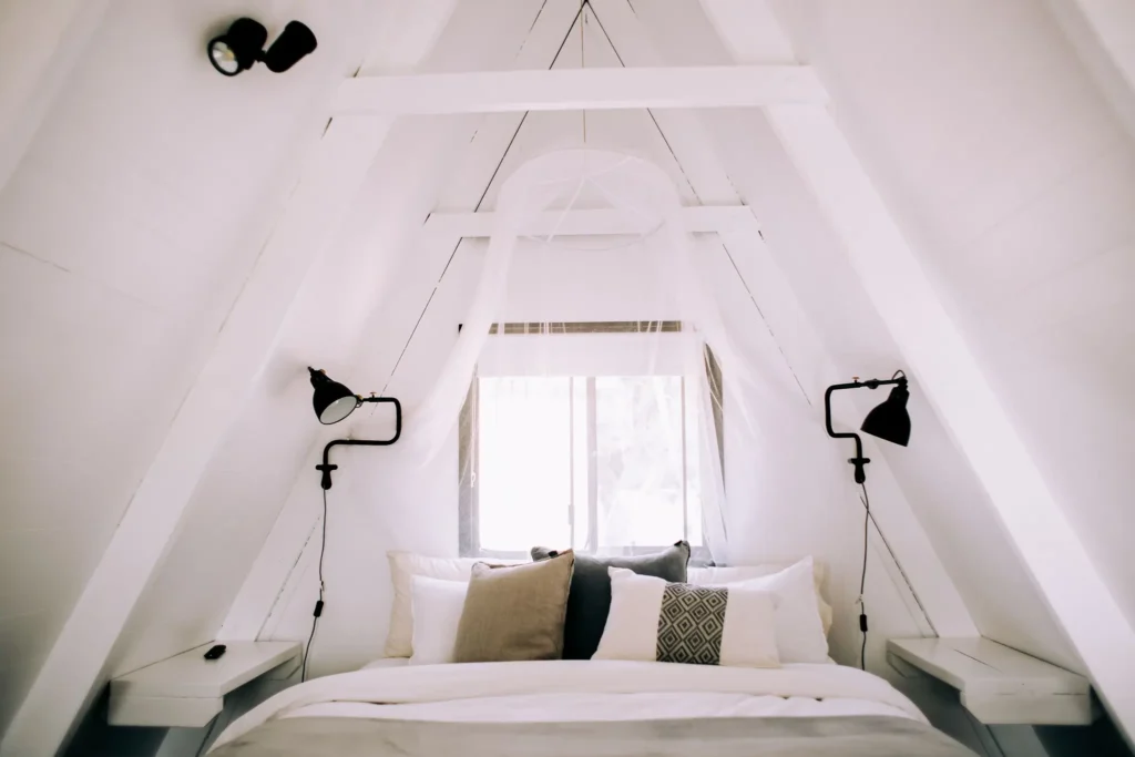 Cabane Itsaso : chambre sous la charpente blanche, lit double et appliques
