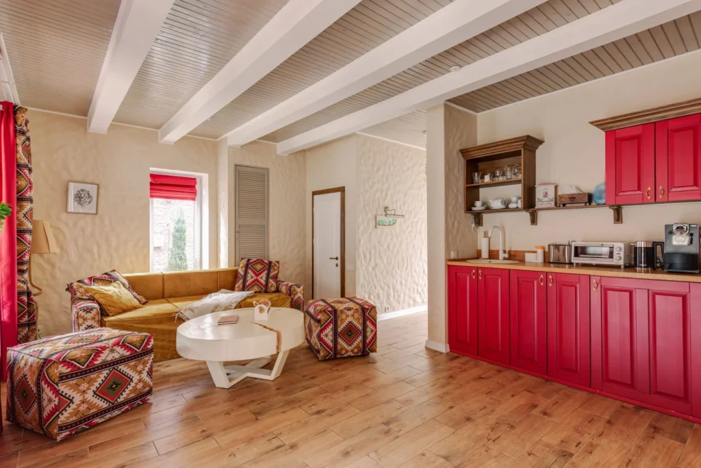 Maison Gorria : séjour sous poutres blanches et cuisine aux placards rouges