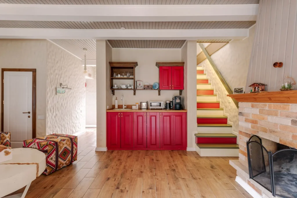 Maison Gorria : cuisine aux placards rouges, escalier et cheminée