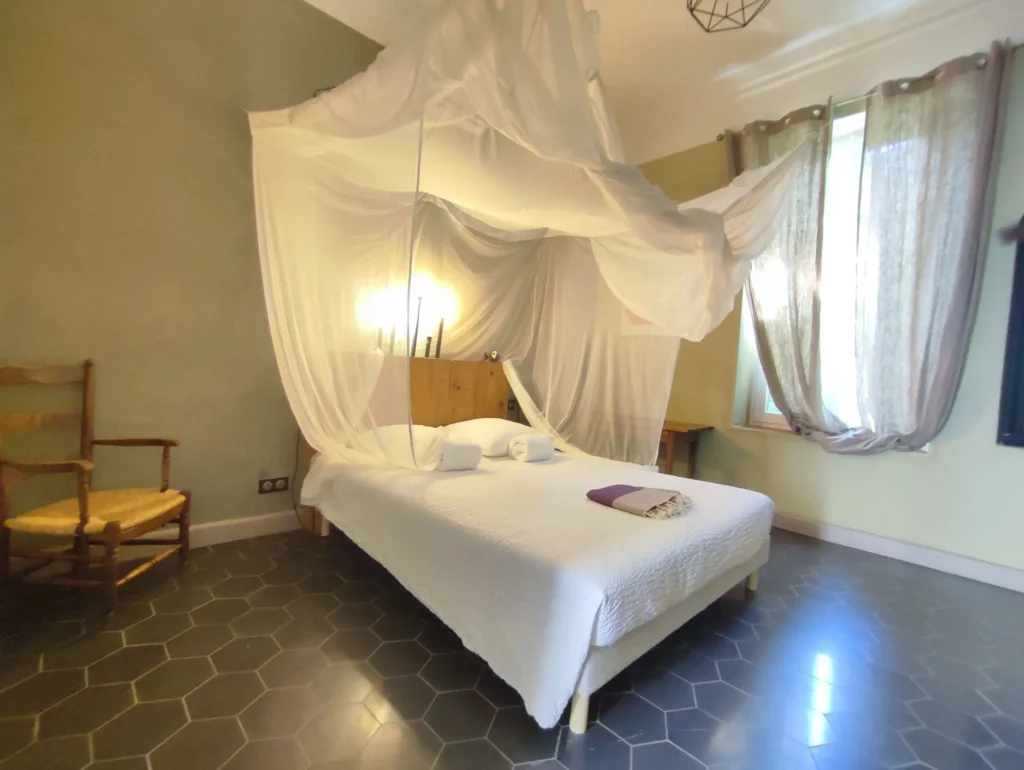 Maison Lur : chambre 3, lit à moustiquaire et carreaux hexagonaux