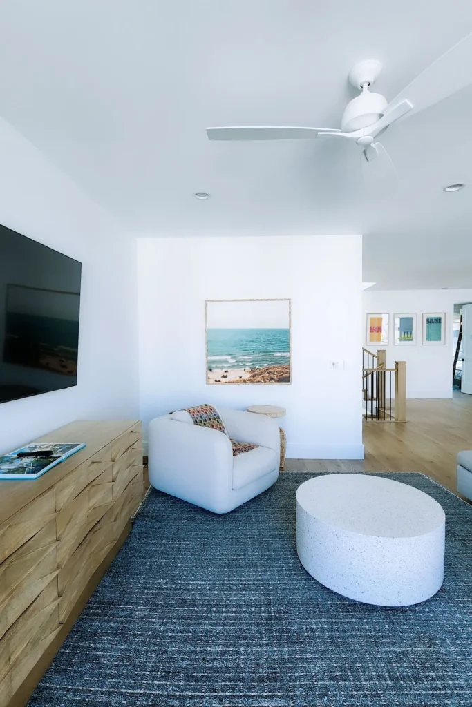 Studio Surf : coin salon lumineux, fauteuil blanc et tapis bleu