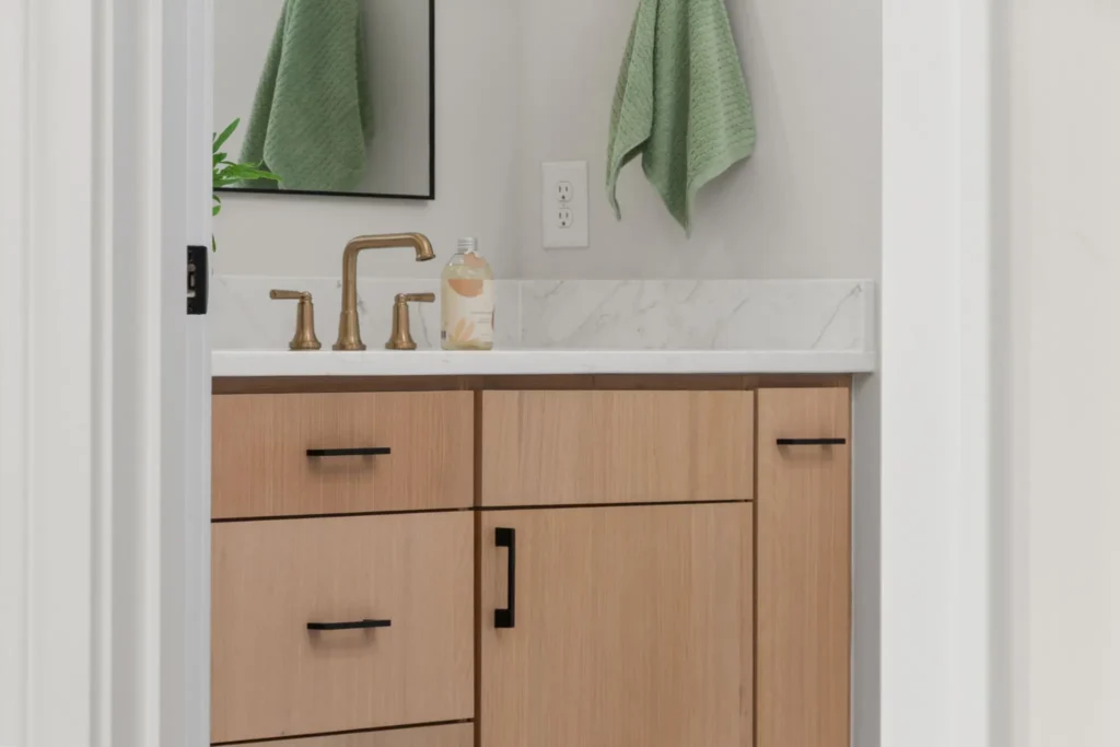 Studio Surf : salle de douche, meuble vasque en bois et serviettes vertes