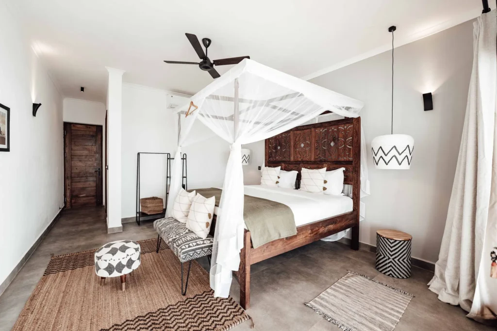 Villa Ilbarritz : suite parentale, lit à baldaquin en bois sculpté et tapis en jute